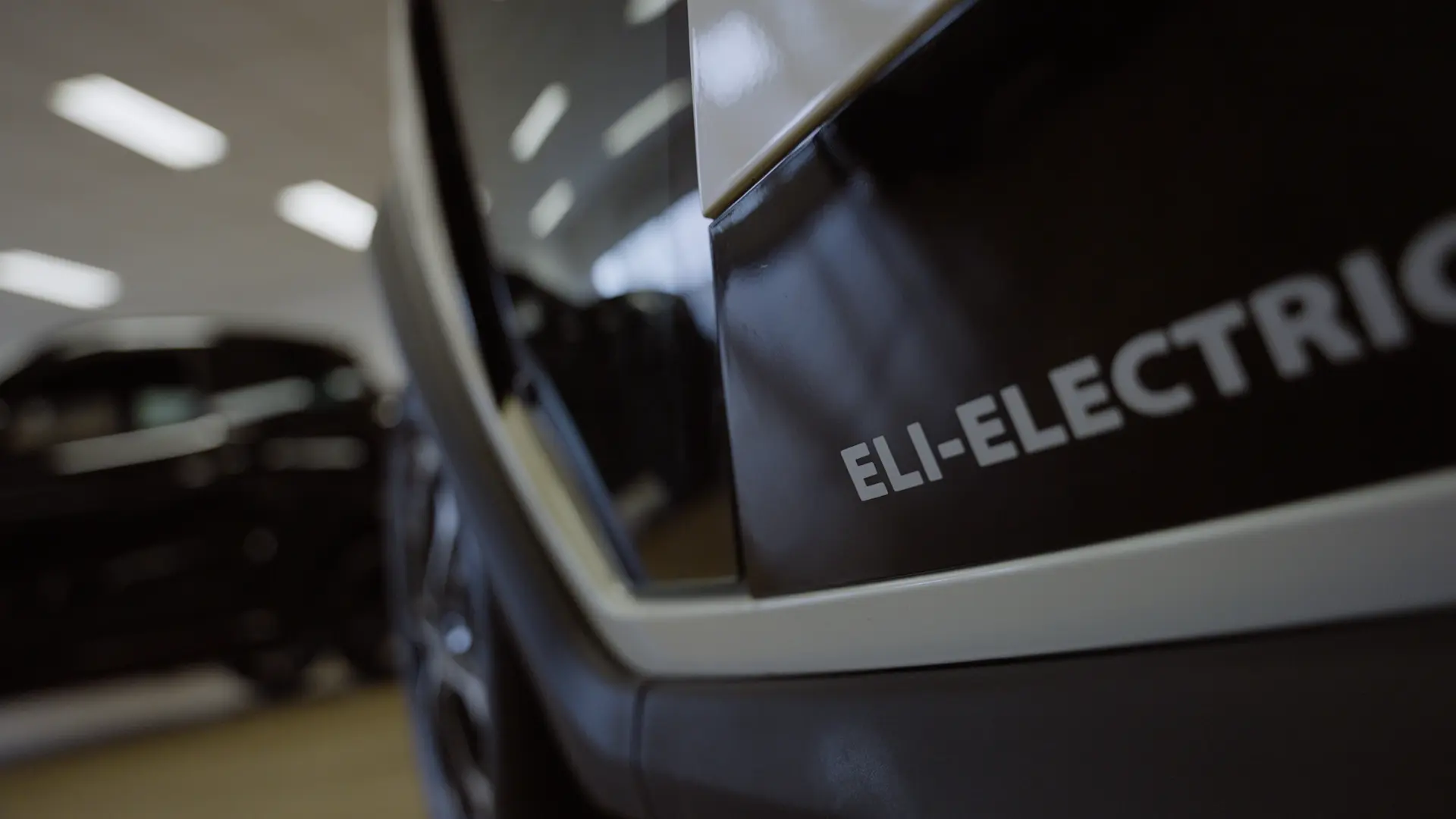 Крупный план логотипа Eli Zero Electric на кузове, подчеркивающий индивидуальность бренда и устойчивые технологии.